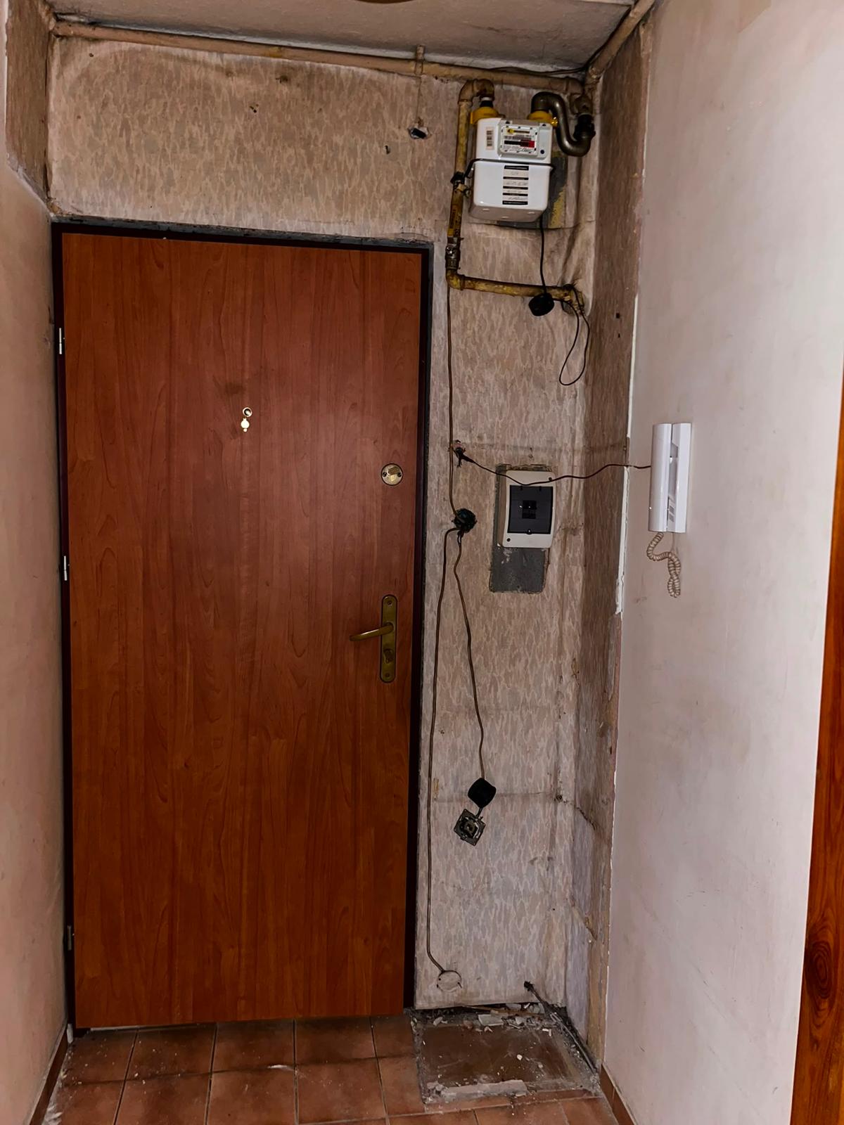 Ten sam korytarz po opróżnieniu — gołe ściany i odsłonięta instalacja
